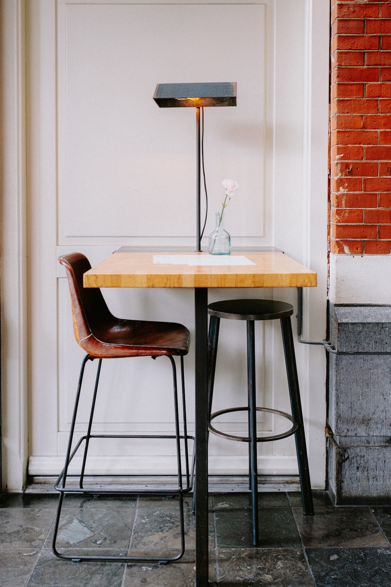 tall desk with two chairs and lamp