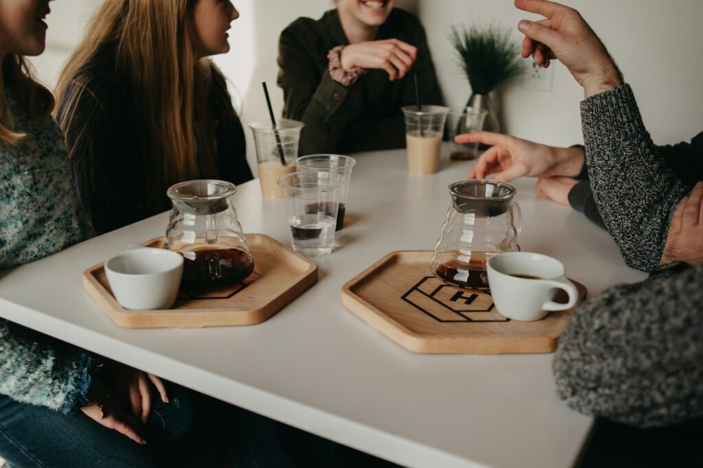 desk with women. they are drinking coffee.