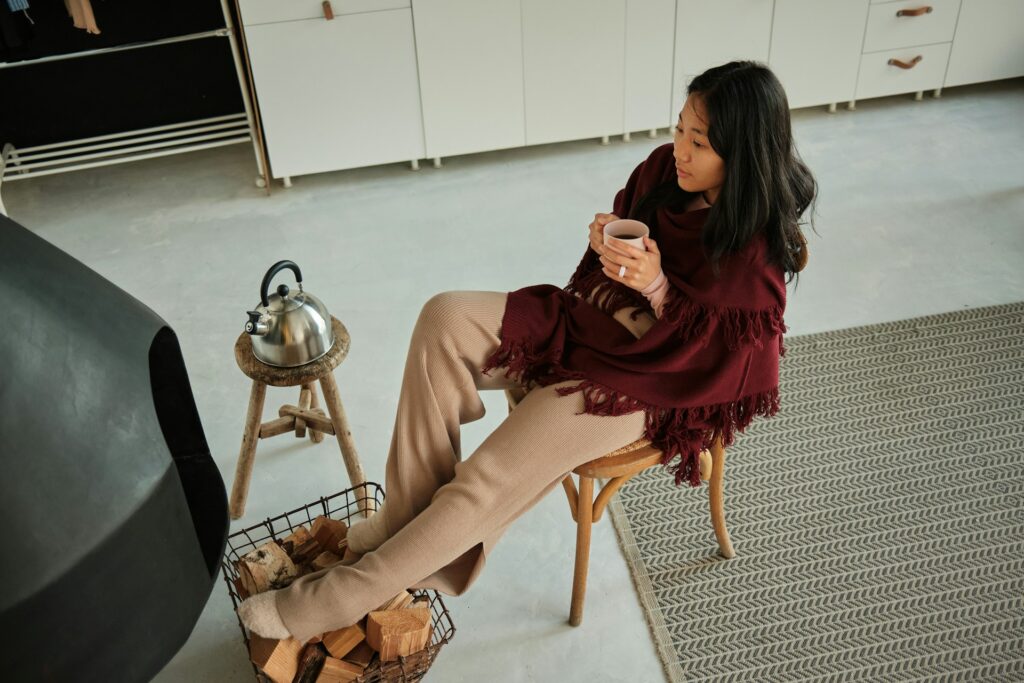 woman sitting in a chair by a fireplace. photo from above.